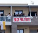 Papa Francesco a Matera, da un balcone campeggia lo striscione "Pace per tutti"